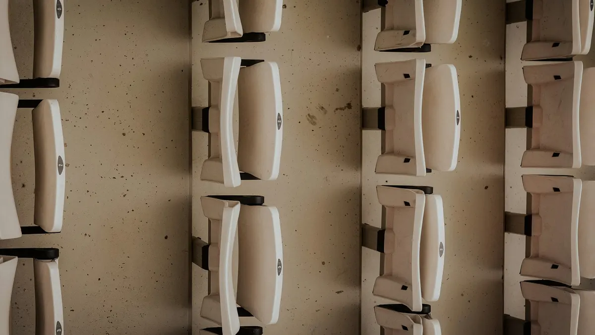Rows of empty folding seats in a venue, seen from above